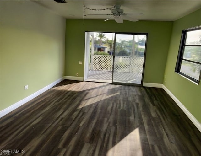 unfurnished room featuring dark wood-style floors, ceiling fan, and baseboards