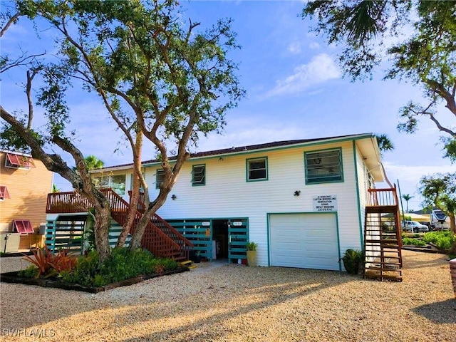 view of front of property featuring driveway, stairway, and an attached garage