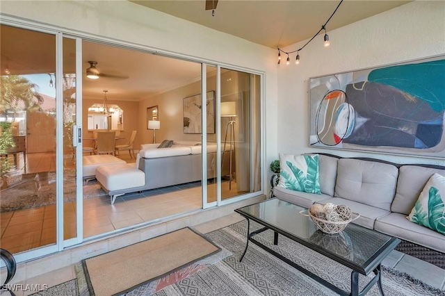 sunroom / solarium featuring ceiling fan with notable chandelier and plenty of natural light