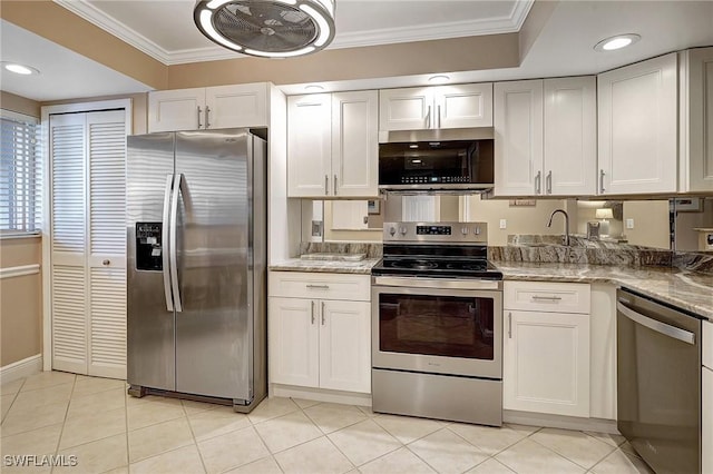 kitchen with white cabinetry, stainless steel appliances, light stone counters, crown molding, and light tile patterned flooring