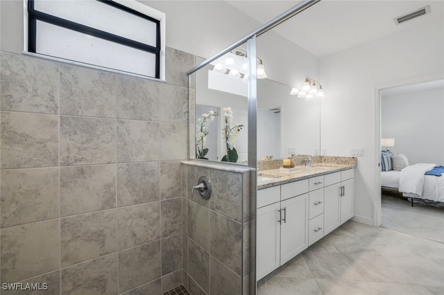 full bathroom featuring vanity, visible vents, connected bathroom, and tiled shower