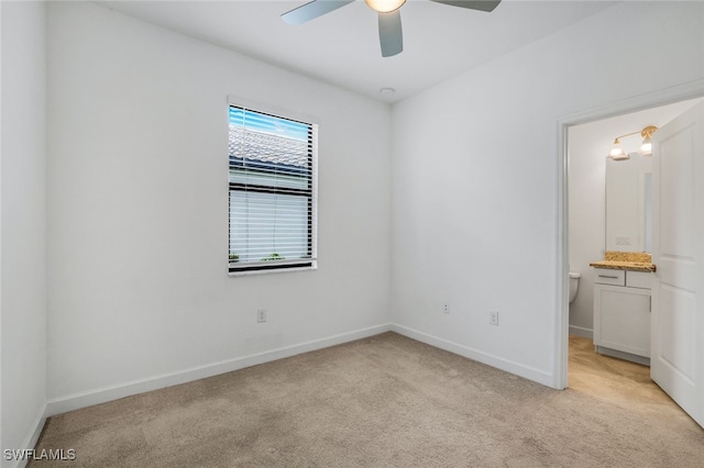 unfurnished room with light carpet, baseboards, and a ceiling fan