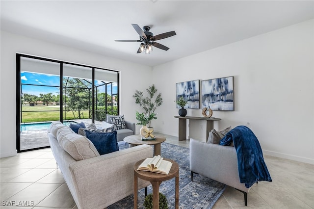 living room featuring ceiling fan, light tile patterned floors, a sunroom, and baseboards