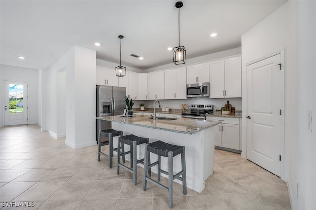 kitchen with appliances with stainless steel finishes, white cabinetry, and a sink