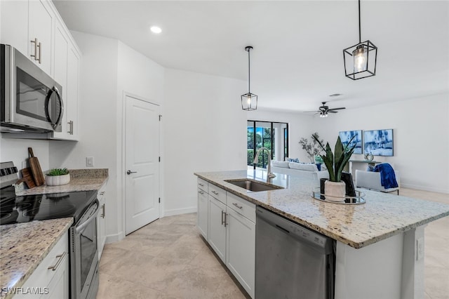 kitchen with a center island with sink, stainless steel appliances, a ceiling fan, white cabinets, and a sink