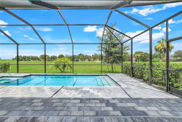 view of swimming pool featuring a lanai, a pool with connected hot tub, a lawn, and a patio