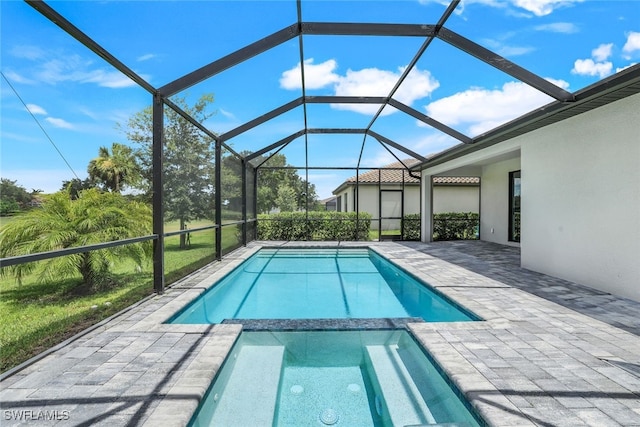 view of swimming pool featuring a pool with connected hot tub, a patio area, and a lanai