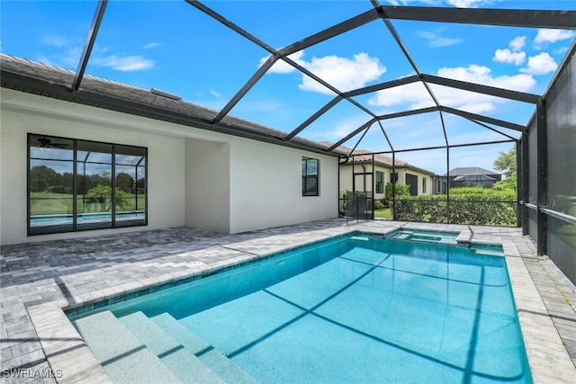 view of swimming pool with glass enclosure, a patio area, and a pool with connected hot tub