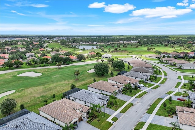 aerial view with golf course view, a water view, and a residential view