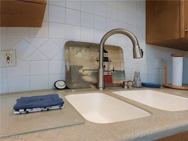 details featuring tasteful backsplash and sink