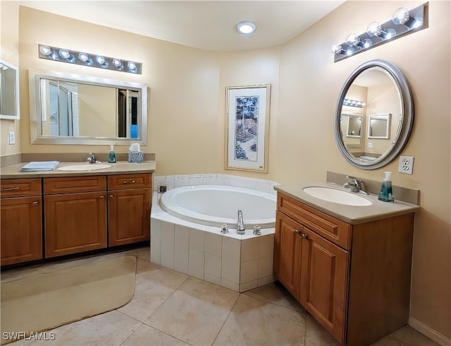 bathroom with vanity, tile patterned flooring, and tiled bath