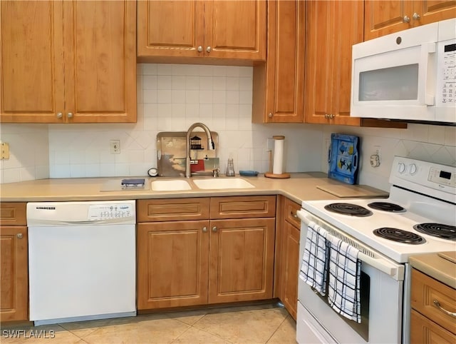 kitchen with sink, white appliances, light tile patterned flooring, and tasteful backsplash