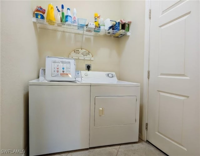 laundry room featuring washing machine and dryer and light tile patterned floors