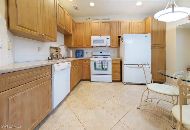 kitchen featuring white appliances, sink, light tile patterned floors, and hanging light fixtures