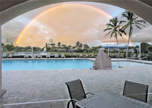 pool at dusk with a patio