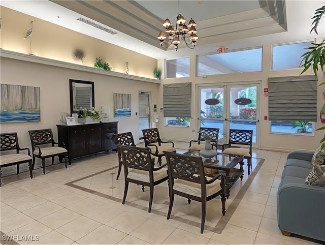 interior space featuring a towering ceiling, light tile patterned flooring, a raised ceiling, and a chandelier