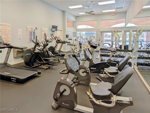 gym with a paneled ceiling and ceiling fan