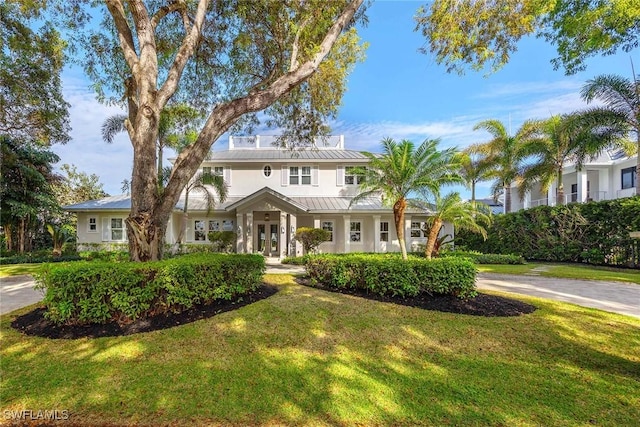 view of front of property with french doors and a front lawn