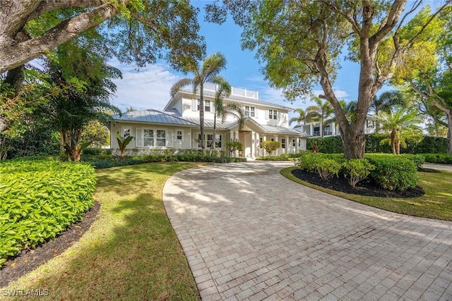 661 6th Ave N, Naples, FL 34102 - view of front facade featuring curved driveway, stucco siding, a metal roof, a standing seam roof, and a front yard