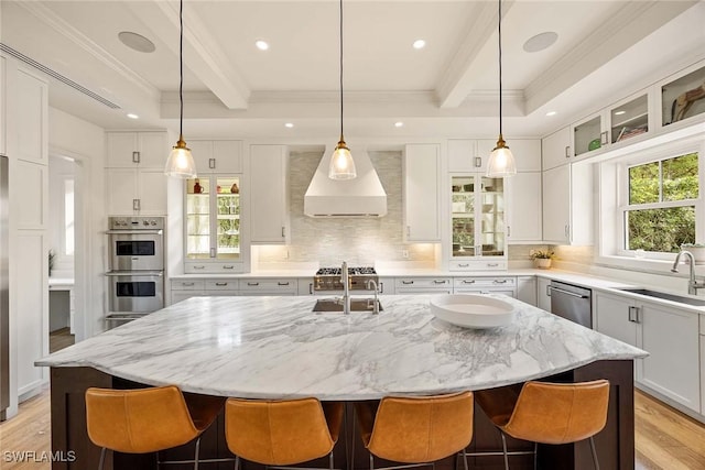 kitchen with beamed ceiling, sink, a kitchen island with sink, and appliances with stainless steel finishes