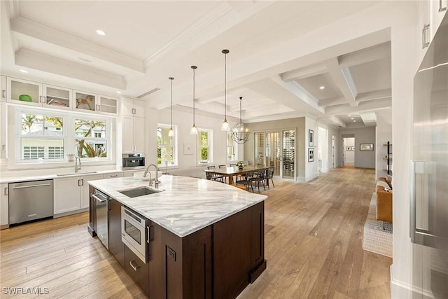 kitchen featuring light stone countertops, appliances with stainless steel finishes, dark brown cabinets, sink, and white cabinetry