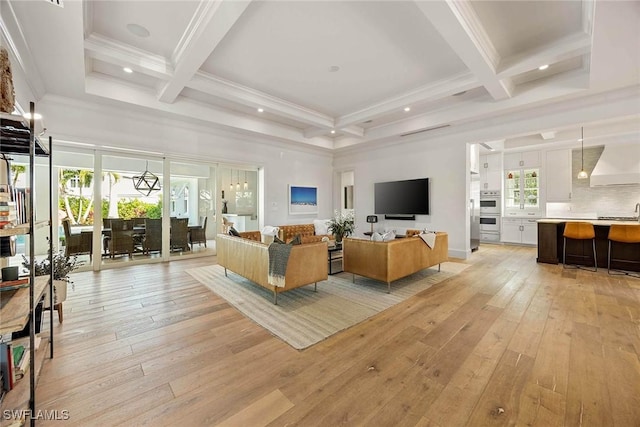 living room featuring beam ceiling, a wealth of natural light, and coffered ceiling