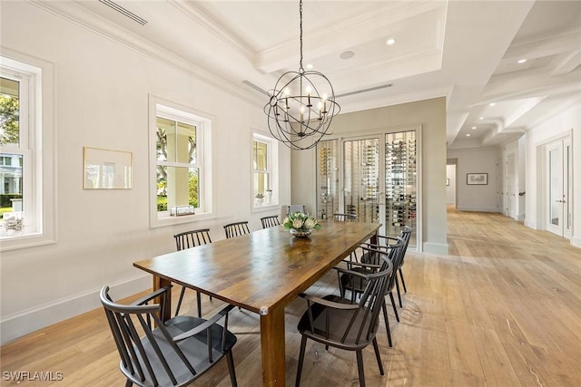 dining space featuring an inviting chandelier, light hardwood / wood-style flooring, and crown molding