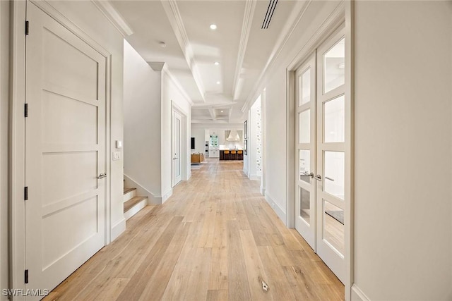 hall featuring beam ceiling, light wood-type flooring, and ornamental molding