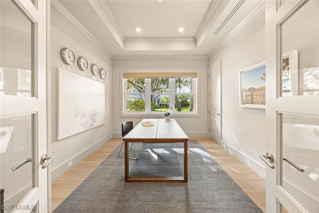 office with a tray ceiling, crown molding, french doors, and light wood-type flooring