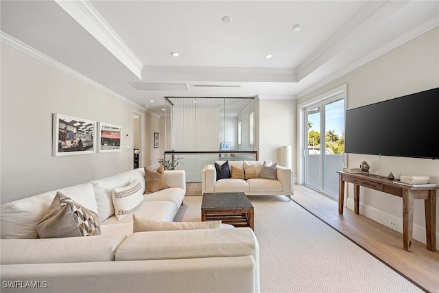 living room with a raised ceiling, light hardwood / wood-style floors, and ornamental molding