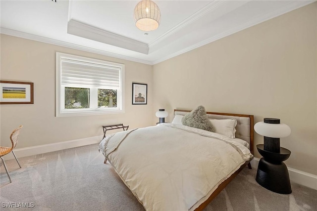 bedroom with a tray ceiling, crown molding, and carpet