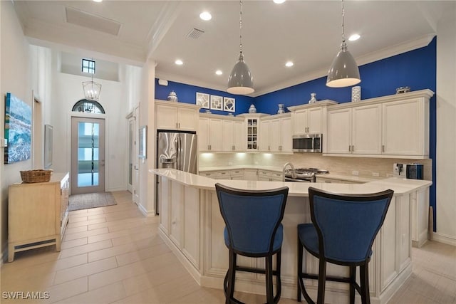 kitchen with tasteful backsplash, a kitchen island with sink, stainless steel appliances, and a kitchen breakfast bar