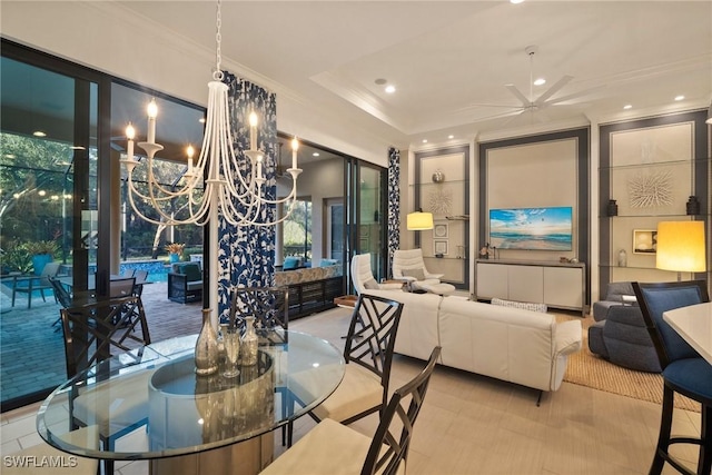 dining area featuring ceiling fan with notable chandelier and a tray ceiling