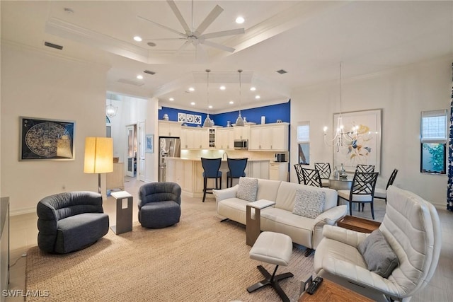 living room with ceiling fan with notable chandelier, a raised ceiling, and ornamental molding