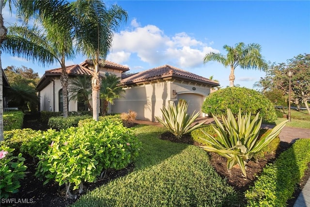 view of front of property featuring a front lawn and a garage