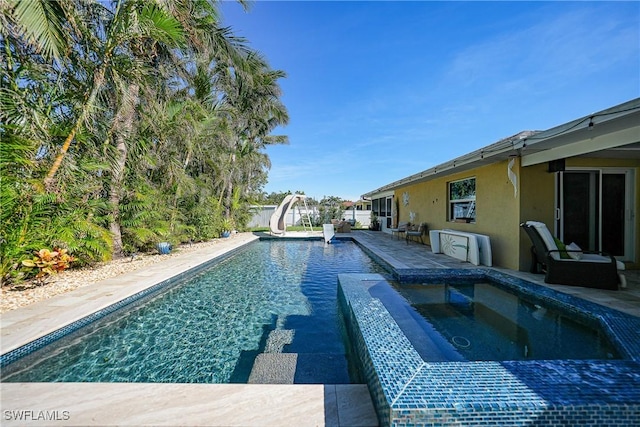 view of pool featuring an in ground hot tub and a water slide