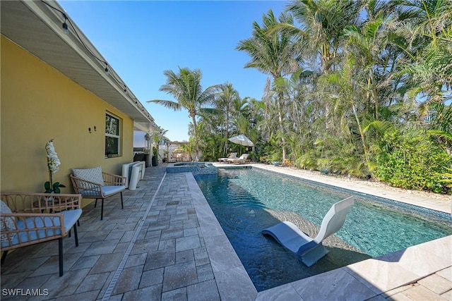 view of swimming pool with an in ground hot tub and a patio