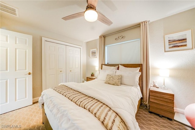 carpeted bedroom with ceiling fan and a closet