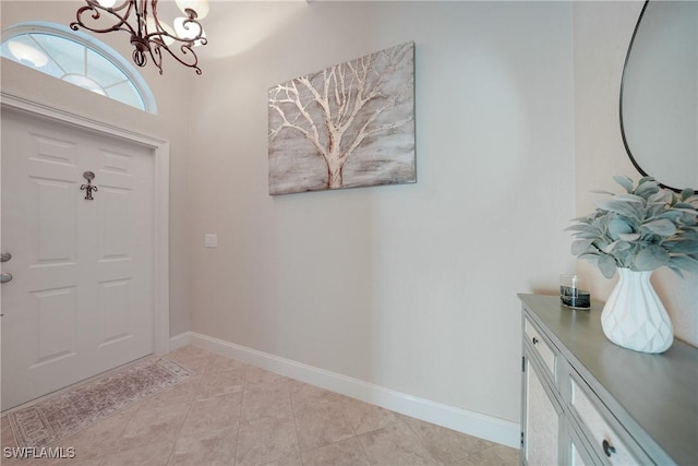 foyer with light tile patterned flooring and an inviting chandelier