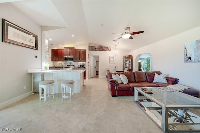 living room with ceiling fan, lofted ceiling, sink, and beverage cooler