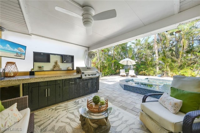 view of patio with area for grilling, ceiling fan, and exterior kitchen