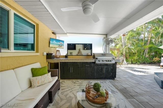 view of patio featuring ceiling fan, area for grilling, and exterior kitchen