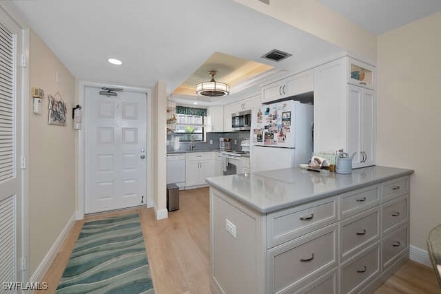 kitchen with gray cabinetry, white appliances, kitchen peninsula, and white cabinets