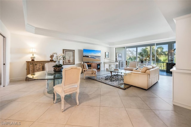 living room featuring a glass covered fireplace, baseboards, and light tile patterned floors