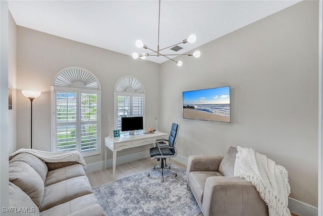 home office with light hardwood / wood-style flooring, vaulted ceiling, and an inviting chandelier