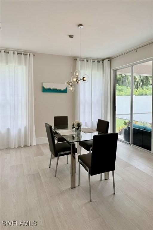 dining area with a notable chandelier and light hardwood / wood-style flooring