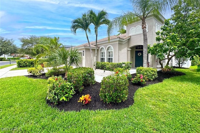 mediterranean / spanish home with a front lawn