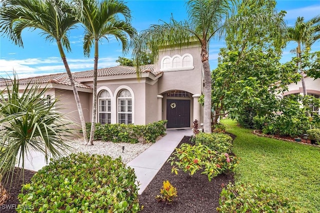 mediterranean / spanish home with a front yard