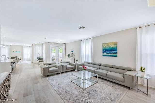 living room with light hardwood / wood-style flooring and french doors