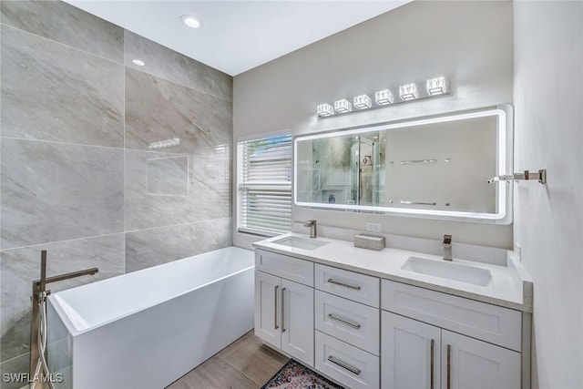 bathroom with vanity, independent shower and bath, and tile walls